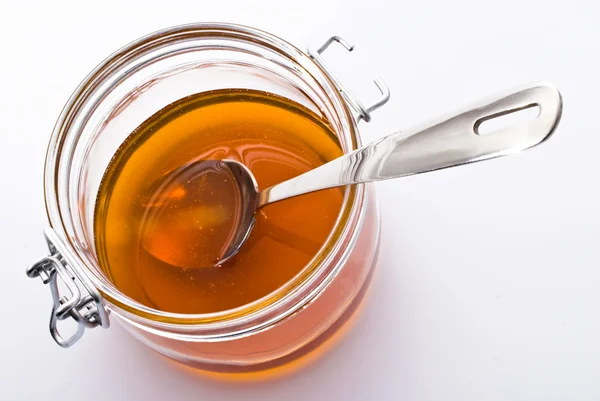 Pote de mel e colher — Fotografia de Stock