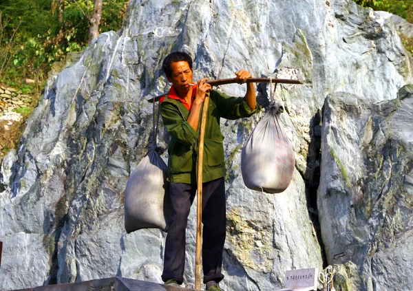 ВУДАНГ-ШАН, Китай - NOV 1, 2007: Человек с большими тюками на st — стоковое фото
