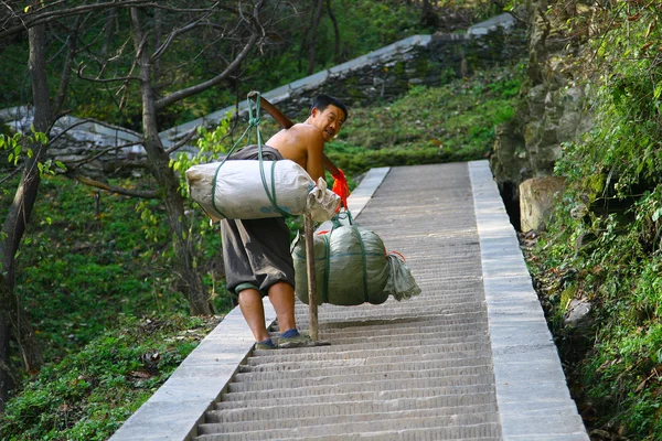 Wudang shan, Kina - 1 nov 2007: mannen med stora balar på st Stockbild