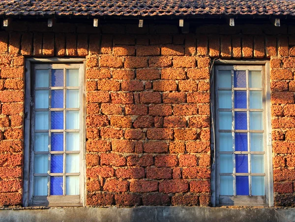 Fenêtres de maison rurale en pierre dans les rayons du soleil couchant — Photo