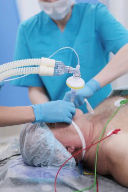 Ameliyattan önce genel anesteziye giriş. Yakın plan. Hastanın yüzünde solunum maskesi. Tıbbi anestezi. Ameliyata hazırlanıyorum. Hayat kurtarma. Bağış konsepti. Dikey fotoğraf.