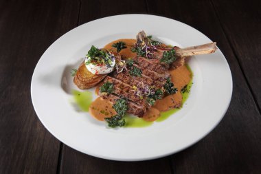 Patates ve yahni ile dana eti. Tabak beyaz tabakta. Karanlık bir arka planda fotoğraf. Restoran için menü kavramı.