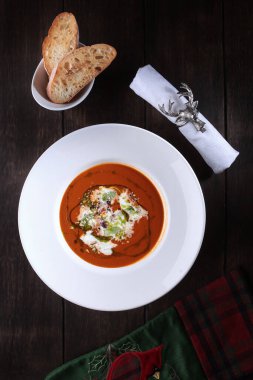 Stracatella peynirli kremalı domates çorbası. Beyaz tabakta yemek. Kızarmış ekmek parçaları. Restoran menüsü konsepti. Dikey fotoğraf. Kızarmış ekmek. Kutlama masası ayarları. Üst manzara. Düz yatıyordu.