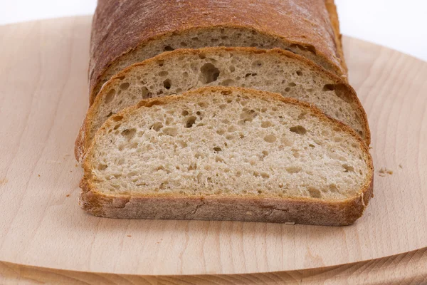Brot in Scheiben auf einem Holzbrett — Stockfoto