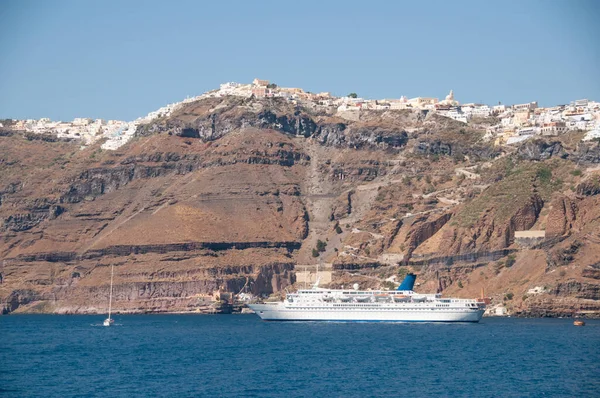 Kalderadaki köyün panoramik hava manzarası ve Yunanistan 'ın Santorini adasındaki bir yolcu gemisi.
