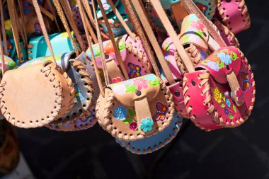 Çeşitli renklerde dekore edilmiş deri çantalar, satılık Meksika hatıra eşyaları.