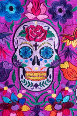 Hand-beaded Mexican women's handbag, made in Chiapas, with a skull and flowers of various colors, with a purple background clipart