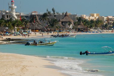 View of the waterfront in Playa del carmen, Mexico, with the lighthouse and fishing boats near the beach
