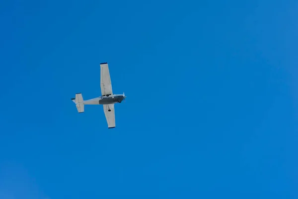 Small single-engine plane flying against blue sky. on blue, Playa del Carmen, Mexico