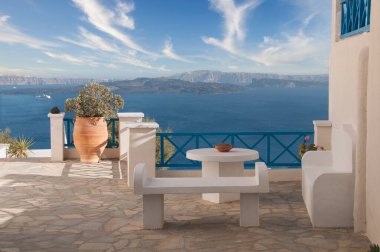 Yunanistan 'ın Santorini adasının kalderası ve denizi üzerindeki Oia' daki açık bir terastan panoramik manzara