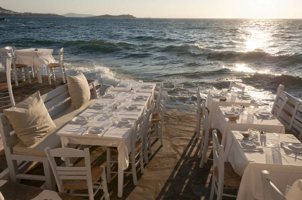 Yunanistan 'ın Mykonos adasındaki köyde bir sahil restoranında masalar