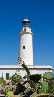 İspanya 'nın Formentera adasındaki La Mola deniz fenerinin dikey görüntüsü mavi gökyüzüne karşı