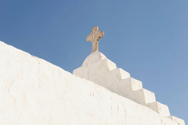Yunanistan 'daki Mykonos adasında mavi gökyüzüne karşı haçı olan bir kilisenin çatısına yakın çekim