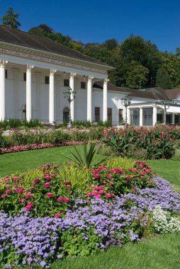 Baden-Baden Kumarhanesi 'nin önündeki çiçek yataklarının adı Kurhaus. Arka planda ağaçlar ve mavi gökyüzü. Güneş ışığı. Baden-Wuerttemberg, Almanya.
