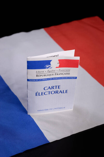 A French voting card leaflet placed on the tricolor French national flag. Copy space.