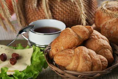 Hamur işleri, meyveler, peynirler, fındıklar, buğdaylar ve marullar masada.