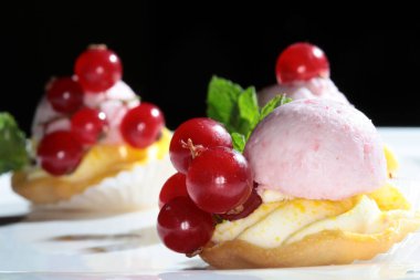 Koyu bir arka plan stüdyosunda kırmızı frenk üzümlü nefis bir pasta.