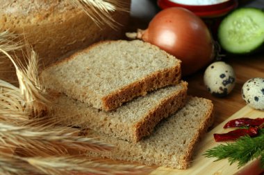 Kesme tahtasında ve diğer yenilebilir stüdyoda dilimlenmiş ekmeğin yakın çekimi.