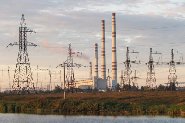Industrielandschaft Wasserkraftwerk Und Stromleitungen Bei Sonnenuntergang lizenzfreie Stockbilder