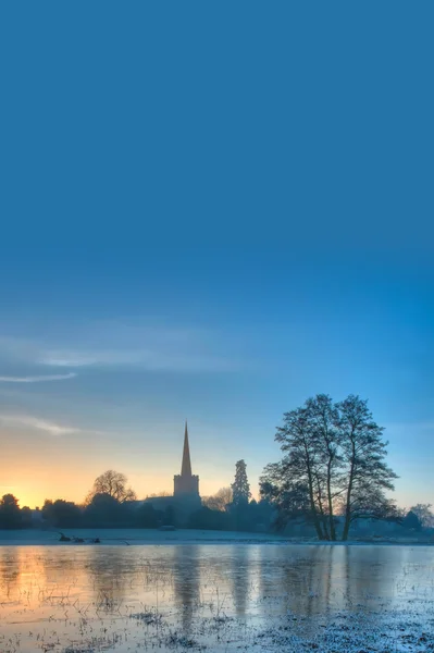 Vintern bakgrund med kyrkan på sunrise — Stockfoto