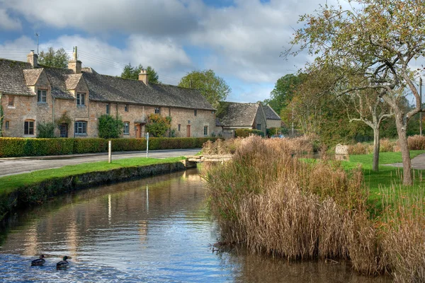 Reihe von Cotswold-Hütten auf dem River Eye, weniger Schlachtung, Gloucestershire, England. — Stockfoto