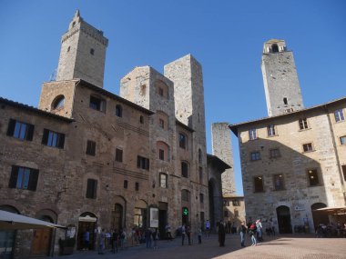 San Gimignano 'daki sarnıç meydanı. Ortasında sekizgen kuyu ve arkasında ortaçağ yüksek kuleleri var.