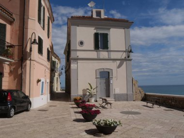 Termoli 'deki Swabian Kalesi' nin duvarları boyunca denize bakan renkli çiçekleri ve balkonu olan Bisceglie Meydanı.