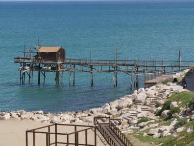 Trabucco yolu, denizdeki antik balıkçılık makinesi, şehir duvarları boyunca Termoli 'deki Swabian Kalesi.