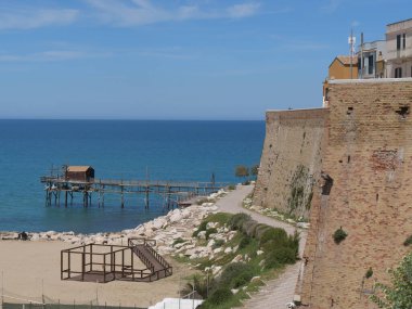 Trabucco yolu, denizdeki antik balıkçılık makinesi, şehir duvarları boyunca Termoli 'deki Swabian Kalesi.