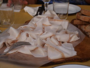 Tahta kesme tahtasının üzerinde servis edilen bir parça Colonnata yağı.