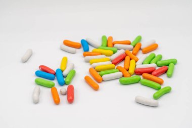 Açık arkaplanda bir avuç renkli tatlı şeker