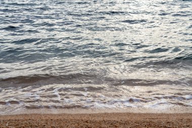 Akşamları sahilde seçici bir dikkatle dalgalar.