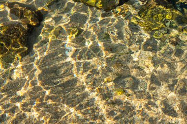 Deniz tabanındaki kayalar kristal berrak deniz suyundan görülebilir.