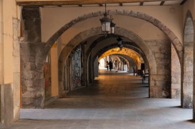Girona, İspanya - 12.20.2021: Eski günlerden kalma yağmur ve ticaretten korunmak için kemerli koridor