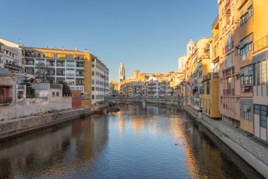 Girona 'nın tarihi merkezindeki nehir kanalı renkli evler ve açık gökyüzü, Eyfel Köprüsü manzarası