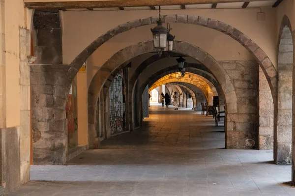 Girona, İspanya - 12.20.2021: Eski günlerden kalma yağmur ve ticaretten korunmak için kemerli koridor