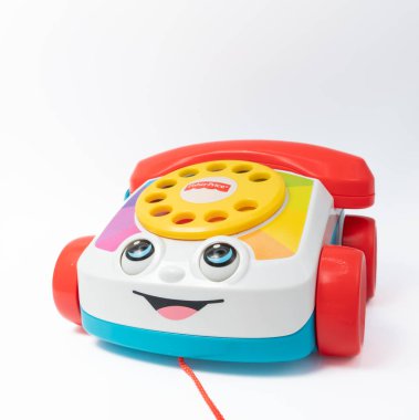 Barselona, İspanya - 12.24.2021: Kırmızı alıcılı çocuk oyuncağı ev telefonu, Fisher-Price tarafından yapılan bir arama ve gülümseme beyaz üzerine izole edilmiş.