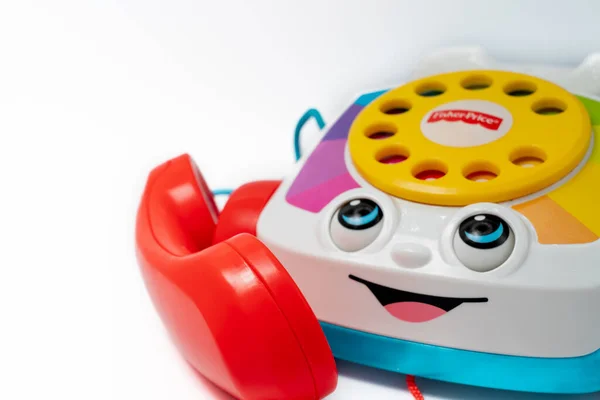 Barselona, İspanya - 12.24.2021: Kırmızı alıcılı çocuk oyuncağı ev telefonu, Fisher-Price tarafından yapılan bir arama ve gülümseme beyaz üzerine izole edilmiş.