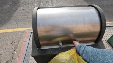 Erkekler çöp torbasını çöp kutusuna atar.