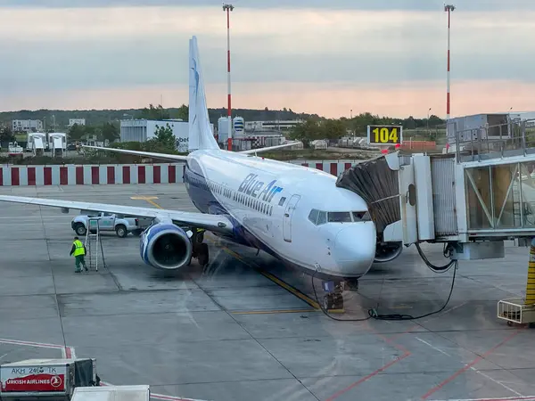 Bucharest, Romania - 05.15.2022: Blue Air plane is parked and ready for loading passengers and luggage, the view from the window of the airport