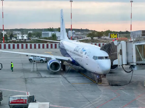 Bucharest, Romania - 05.15.2022: Blue Air plane is parked and ready for loading passengers and luggage, the view from the window of the airport