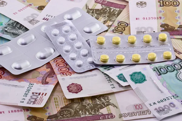 Медичні таблетки на банкноті як символ високих витрат — стокове фото