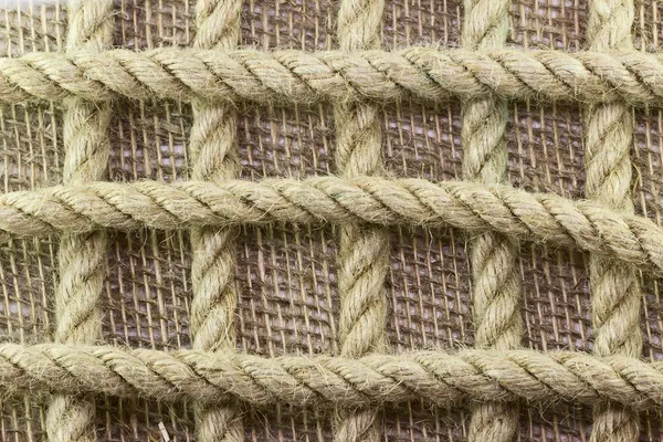 Jute rope on burlap background — Stock Photo, Image