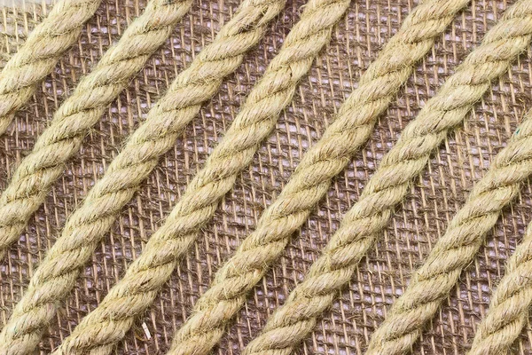 Jute rope on burlap background — Stock Photo, Image