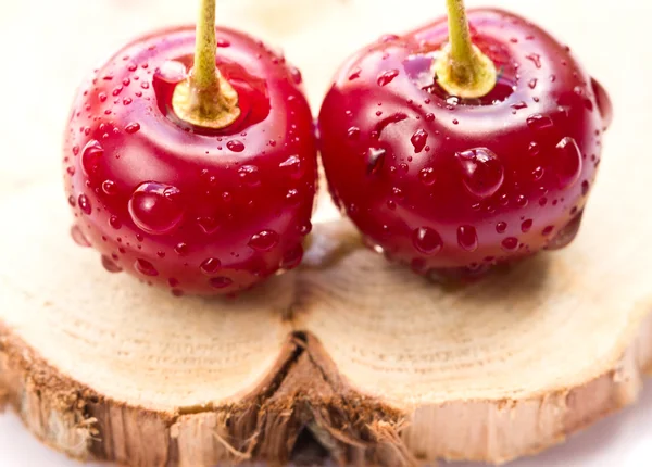Two cherries on a wooden board — Stock Photo, Image