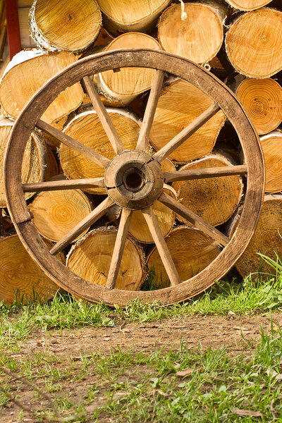 Old wagon wheel on a background of wood