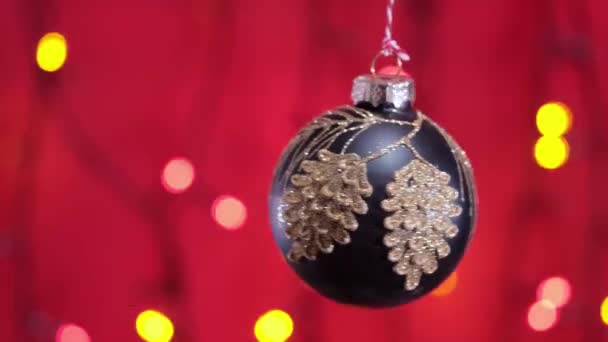 4k. Jouet de balle de nouvel an noir et guirlande clignotante avec lumières rondes défocalisées — Video