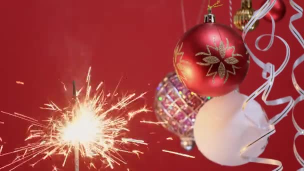 4k. Humor de Navidad. Sparkler Brillante luz de Navidad ardiente sobre fondo rojo — Vídeos de Stock