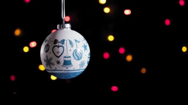 4kだ。白いクリスマスボールのおもちゃとラウンドの焦点を当てたライトとブリンクガーランド. — ストック動画