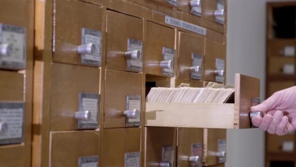 Kartu katalog di pustaka. Seorang pria sedang mencari informasi dalam lemari file. — Stok Video
